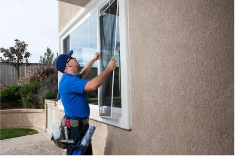 man installing window outside a home