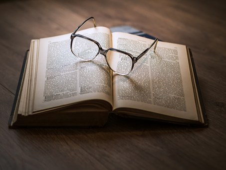 glasses on top of book open to read for young people